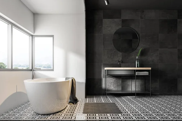 Bathroom interior with grey tile walls, a tiled floor, a bathtub under a large window, a sink and a round mirror. 3d rendering — Stock Image Bathroom Interior Grey Tile Walls Tiled Floor Bathtub Large Window Royalty Free Stock Photos