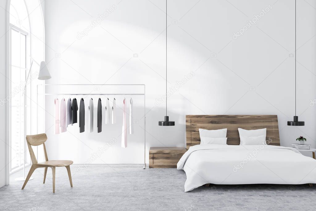 Scandinavian style bedroom with white walls, a tiled floor, a clothes rack, and a master bed with bedside tables. 3d rendering mock up