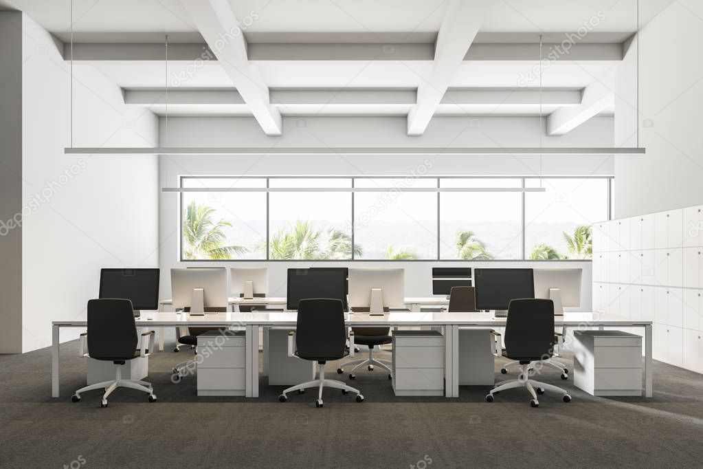 Company office interior with a gray carpet and rows of white computer desks. Industrial style interior with white walls and large windows with a tropical view. 3d rendering mock up