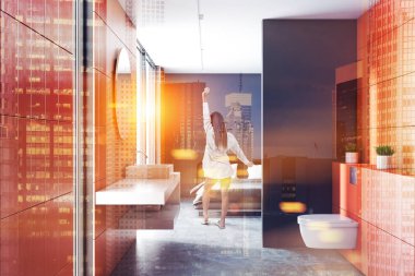 Beton zemin, beyaz lavabo ve tuvalet ile modern turuncu duvar banyo iç. Arka planda gri yatak odası. Kadın pijama. 3D render sahte tonlu görüntü çift pozlama şehir kadar