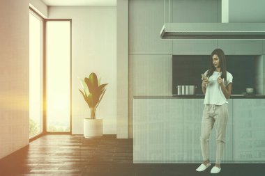 Kadın koyu ahşap zemin, beyaz dolaplar ve mutfak tezgahı ile beyaz duvar mutfak iç ve bir lavabo ile bir ada. Loft windows. 3D render sahte kadar çift tonlu görüntü pozlaması