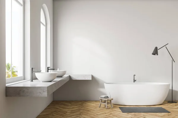 White wall bathroom interior with wooden floor, arched windows, white bathtub, and double sink. Floor lamp. 3d rendering mock up