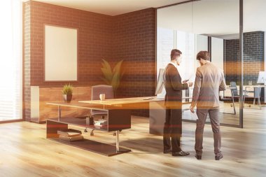 Modern Yöneticisi office köşe bir ahşap zemin, siyah tuğla duvarlar, bir şık bilgisayar masa ve poster çerçevesi kadar sahte. Görüntü 3D render konuşurken iki iş adamları tonda