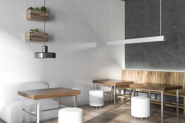 Coffee shop corner with gray walls, wooden tables with white round chairs and original ceiling lamps. 3d rendering mock up