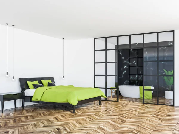 Modern bedroom corner with white walls, a wooden floor, bright green master bed and a black marble bathroom seen through a glass wall. 3d rendering mock up