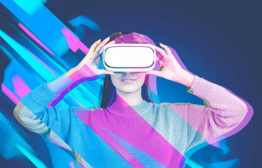 Çekici genç kadın bir kazak ve mavi bir arka plan üzerinde duran vr gözlük. 3D gözlük görsel efekt. Merhaba teknoloji kavramı. Tonlu görüntü pozlama sahte katlayın