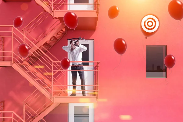 商人用十字弓射击红色气球与目标标志站立在紧急台阶红色大厦 成功的启动项目概念 渲染模拟色调图像 — 图库照片