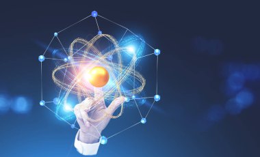 İşkadını el üzerinde parlayan altın ve mavi atom modeli dokunmadan koyu mavi arka plan bulanık. Bilim, kimya ve fizik kavramı. Kopya alanı görüntü çift pozlama tonda