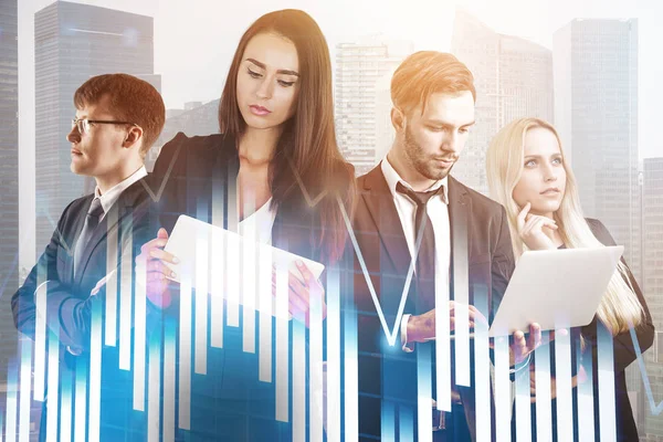 Diverse business team members standing together with gadgets over morning cityscape background. Graphs and diagrams foreground. Toned image double exposure copy space