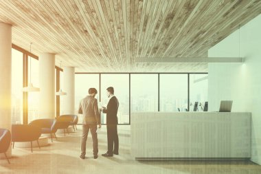 Ahşap tavan, beyaz resepsiyon masası ve Sehpalar yakınındaki mavi koltuk sırasının beyaz duvarlar ve sütunlar office Resepsiyon salonunda konuşurken işadamları. Çift tonlu görüntü pozlaması