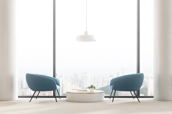 全景起居室内有圆形茶几 蓝色扶手椅 白色柱子和带有城市风貌的窗户 — 图库照片