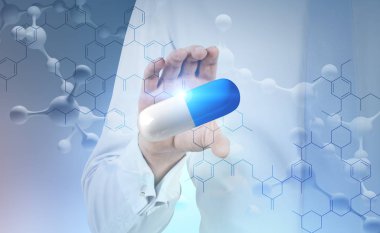 Büyük beyaz mavi hap kapma molekül model ve mavi atomik kılavuz arka plan üzerinde beyaz gömlekli adamın elini. Kimya, fizik ve eczane kavramı. Çift tonlu görüntü pozlaması