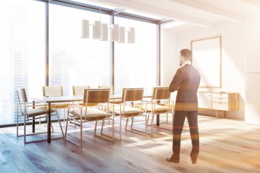 Beyaz duvarları, bir ahşap zemin, sandalye ile uzun bir masa ve dolap dikey posteri başlık çerçevesi kadar alay ile panoramik yemek odası köşede duran iş adamı. Tonlu görüntü