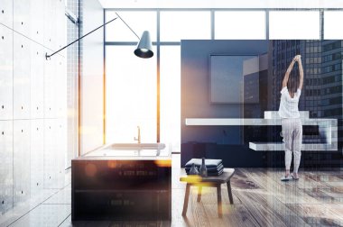 Beton ve gri banyo iç ahşap zemin, gri bir küvet, çift lavabo ve bir çatı penceresi ile cityscape sabah germe kadın. Görüntü çift pozlama City tonda