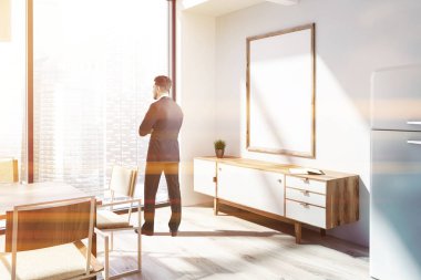 Panoramik yemek odası ahşap zemin, ahşap masa ve beyaz sandalye ile köşesinde ayakta iş adamı. Poster çerçevesi kadar dikey sahte çekmeceli ayarlayın. Modern cityscape. Resim sahte tonda