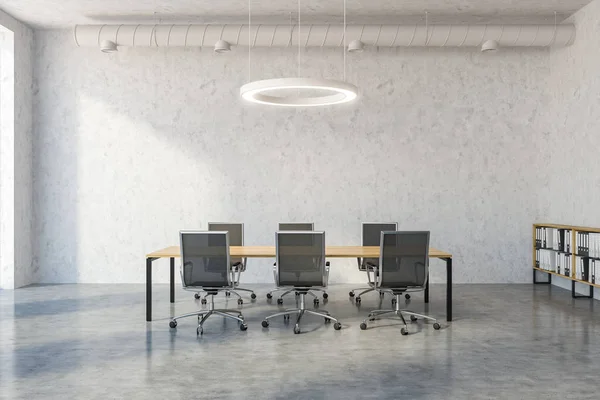 Industrial style meeting room interior with concrete walls and floor, a wooden table and metal chairs. Round ceiling lamp and pipes. 3d rendering copy space