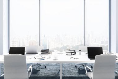 Gri zemin ve üzerlerinde duran dizüstü bilgisayarlar ile dört beyaz bilgisayar masaları ile panoramik ofis iç. 3D render