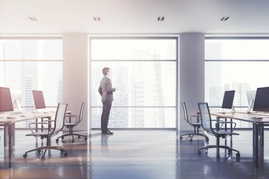 Siyah bilgisayar ayakta beyaz minimalist beyaz ofis ahşap fayans döşeme ve çatı windows ile tablolarda ekranlar. City adlı arıyor işadamı yan görünüm. Tonlu görüntü