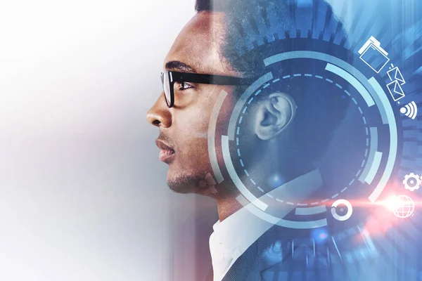 Side view of handsome serious African American businessman looking forward. Futuristic interface and internet hud in the foreground. Marketing, advertising concept. Toned image double exposure mock up