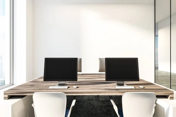 Black computer screens standing on wooden tables in minimalistic white office with concrete floor and loft windows. 3d rendering copy space