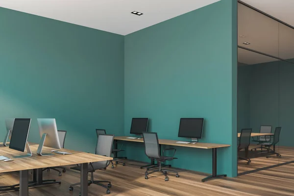 Stylish dark green wall office interior with wooden desks with computers and dark wooden floor. Glass wall meeting room in the background. 3d rendering copy space