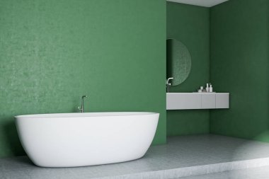 Yeşil duvarlar, beton zemin, beyaz küvet ve yuvarlak aynalı lavabo ile modern banyo köşesi. 3D render