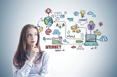 Mavi gömlek ayakta renkli Internet simgeleri ile gri duvarının yakınında dalgın genç iş kadını. Merhaba teknoloji kavramı