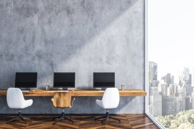 Gri duvar başlangıç ofis iç ahşap zemin, uzun ahşap masa üstünde üç bilgisayar ekranları ile birlikte. Küçük iş kavramı. 3D render kopya alanı