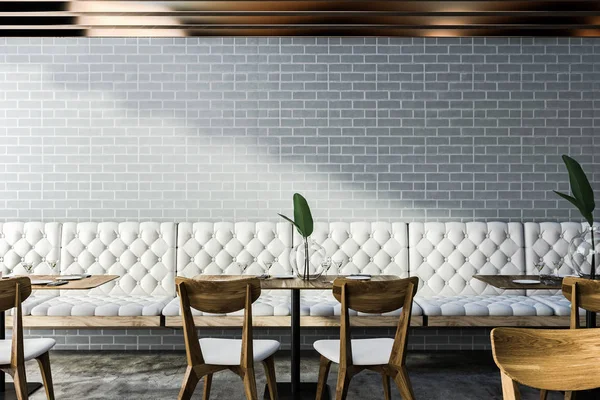 现代咖啡厅的角落 设有灰色砖墙 混凝土地板 带椅子的方形桌子和白色沙发 — 图库照片