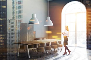 Sarışın işkadını modern yemek odası köşedeki Gri duvarlar, ahşap zemin, küçük sandalye ve kemerli pencere ile uzun tablo. Çift tonlu görüntü pozlaması