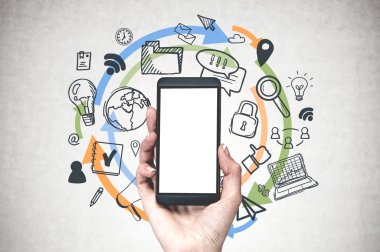 Kadın el Smartphone sahte ekranı ile bilgisayar ve internet simgeler ve renkli oklar üzerinde çizilmiş beton duvar arka plan üzerinde tutarak.
