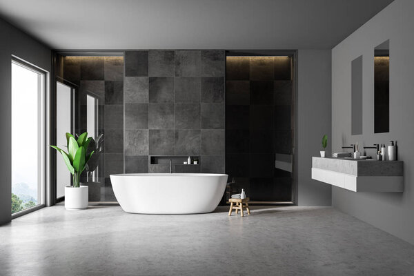 Modern bathroom interior with black tile walls, concrete floor, white bathtub and double sink. Loft window. 3d rendering