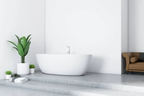 现代化的浴室内配有白色墙壁 混凝土地板 白色浴缸和棕色沙发 — 图库照片