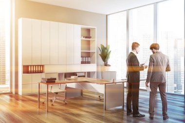 Gri duvarlar CEO'su ofiste iç ahşap zemin, çatı windows, beyaz bilgisayar sandalyeler ve gri kitaplık ile konuşan iş insanlar. Tonlu görüntü