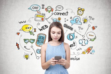 Uzun sarı saçlar smartphone iki eliyle tutarak ve ekrana bakarak mavi elbise giyen genç kadınla. Beton duvar ile renkli sosyal medya simgeler