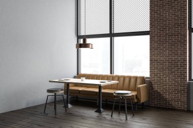 Işık gri ve tuğla duvarlar, ahşap zemin, yuvarlak sandalye ve kahverengi kanepe ile dikdörtgen masa ile modern restoran iç. 3D render