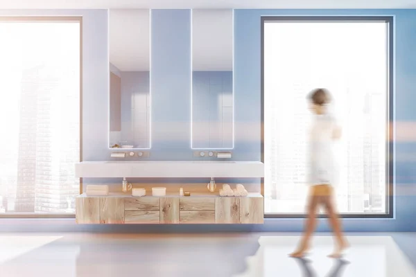 走在现代浴室与蓝色的墙壁 白色的地板 双水槽与木台面下和两个狭窄的镜子 色调图像模糊 — 图库照片