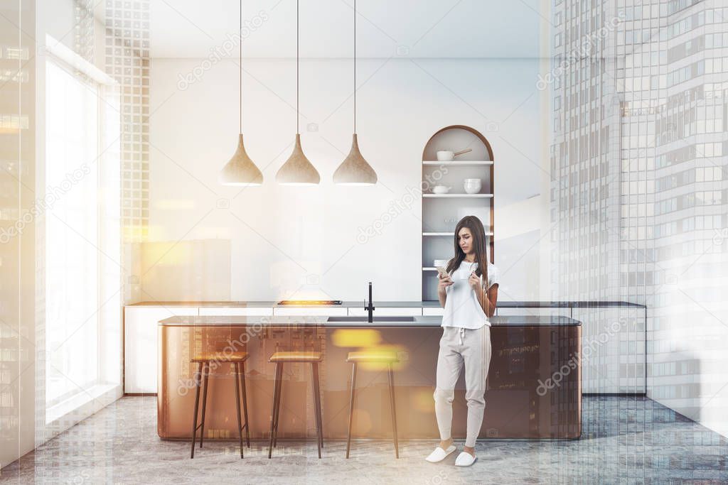 Woman standing in modern kitchen with white walls, concrete floor, arched cupboard, white countertops with built in cooker and wooden bar with stools. Toned image double exposure