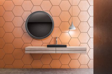 Siyah banyo lavabo ahşap tezgah turuncu petek desen duvar ve yuvarlak ayna ile odada tutuyoruz. 3D render