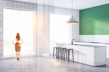 Kadın çatı katı mutfak yeşil ve beyaz duvarlı köşesinde beyaz mutfak tezgahı ile Ocak ve beyaz bar tabureleri ile inşa. Çift tonlu görüntü pozlaması