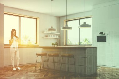 Kadın köşesindeki beyaz duvarlar, ahşap zemin, küçük bir pencere ile modern mutfak aletleri, bar tabureleri ile ve bir fırın beyaz mutfak tezgahı ile inşa. Çift tonlu görüntü pozlaması