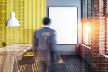 Adam sarı, gri ve tuğla duvarlar, koyu ahşap zemin ve siyah, kırmızı ve sarı sandalye ile uzun ahşap masa ile modern yemek salonunda. Dikey poster. Tpned görüntü çift pozlama kadar sahte bulanıklık