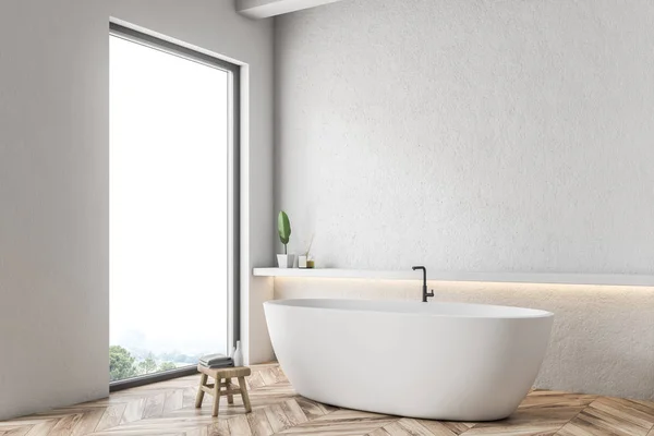 Corner of modern bathroom with white walls, wooden floor and white bathtub standing next to a shelf on the wall. 3d rendering
