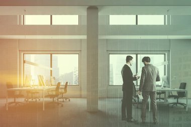 Endüstriyel stil office halı zemin ve onlara yakın duran gri sandalye ile bilgisayar tabloları satırları üzerinde beyaz duvarlı yan görünüm. İş adamları. Çift tonlu görüntü pozlaması