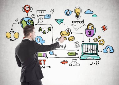 Karanlıkta Genç sakallı işadamı yan görünüm uygun beton duvar çizim renkli Internet simgeleri bir marker ile.