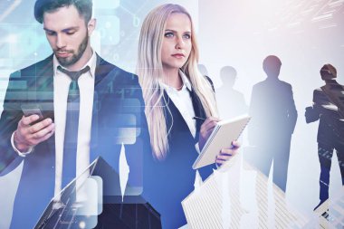 Yakışıklı işadamı smartphone ve Not defteri konumu üzerinde iş takım siluetleri dijital arabirimi ile beyaz arka plan üzerinde olan güzel sarışın meslektaşı ile. Çift tonlu görüntü pozlaması