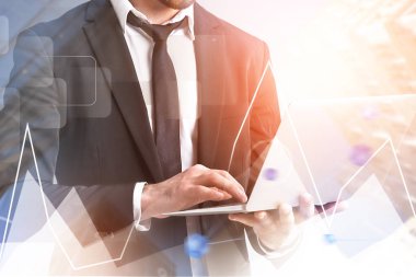 Tanınmayan işadamı ile Laptop ayakta bulanık gökdelenler arka plan grafiği ve ağ arabirimi ön plan ile üzerinde çalışma. Çift tonlu görüntü pozlaması