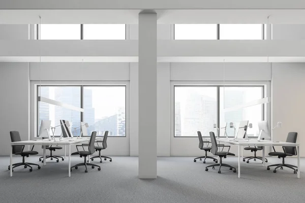 Side view of industrial style office with white walls, carpet on the floor and rows of computer tables with gray chairs standing near them. 3d rendering