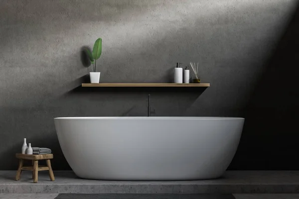 Minimalistic bathroom interior with gray walls, concrete floor, white bathtub with shelf for shampoo and cream above it. 3d rendering