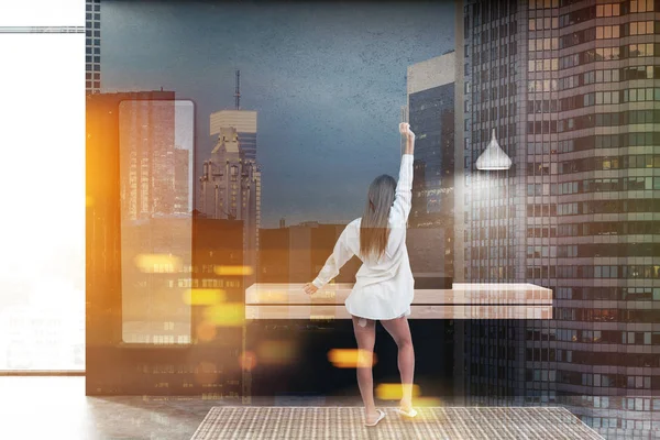 Kadın siyah duvarlar, beton zemin, siyah banyo iç ayakta duran ahşap tezgah lavabo ve dikey ayna dar. Çift tonlu görüntü pozlaması